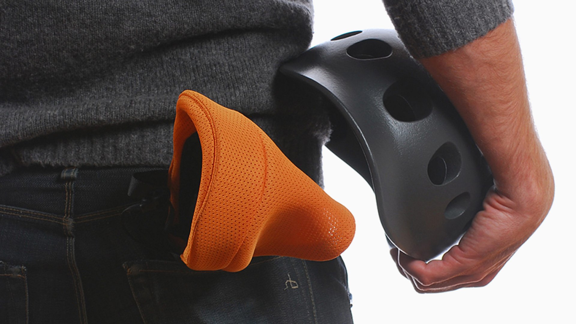 Orange bicycle helmet with ventilation holes and dark background