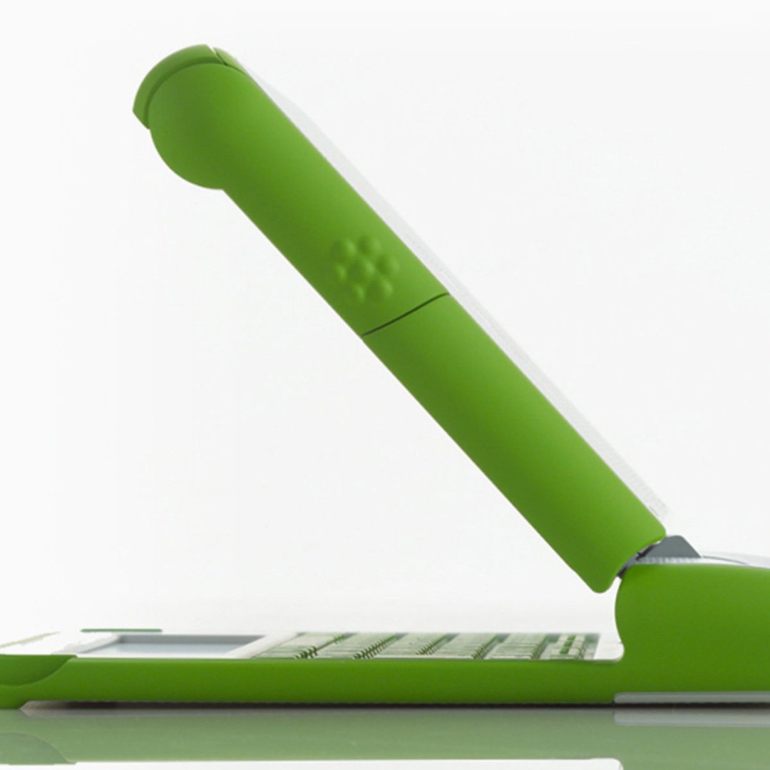 OLPC XO Laptop with green ergonomic keyboard stand designed for elevated typing posture