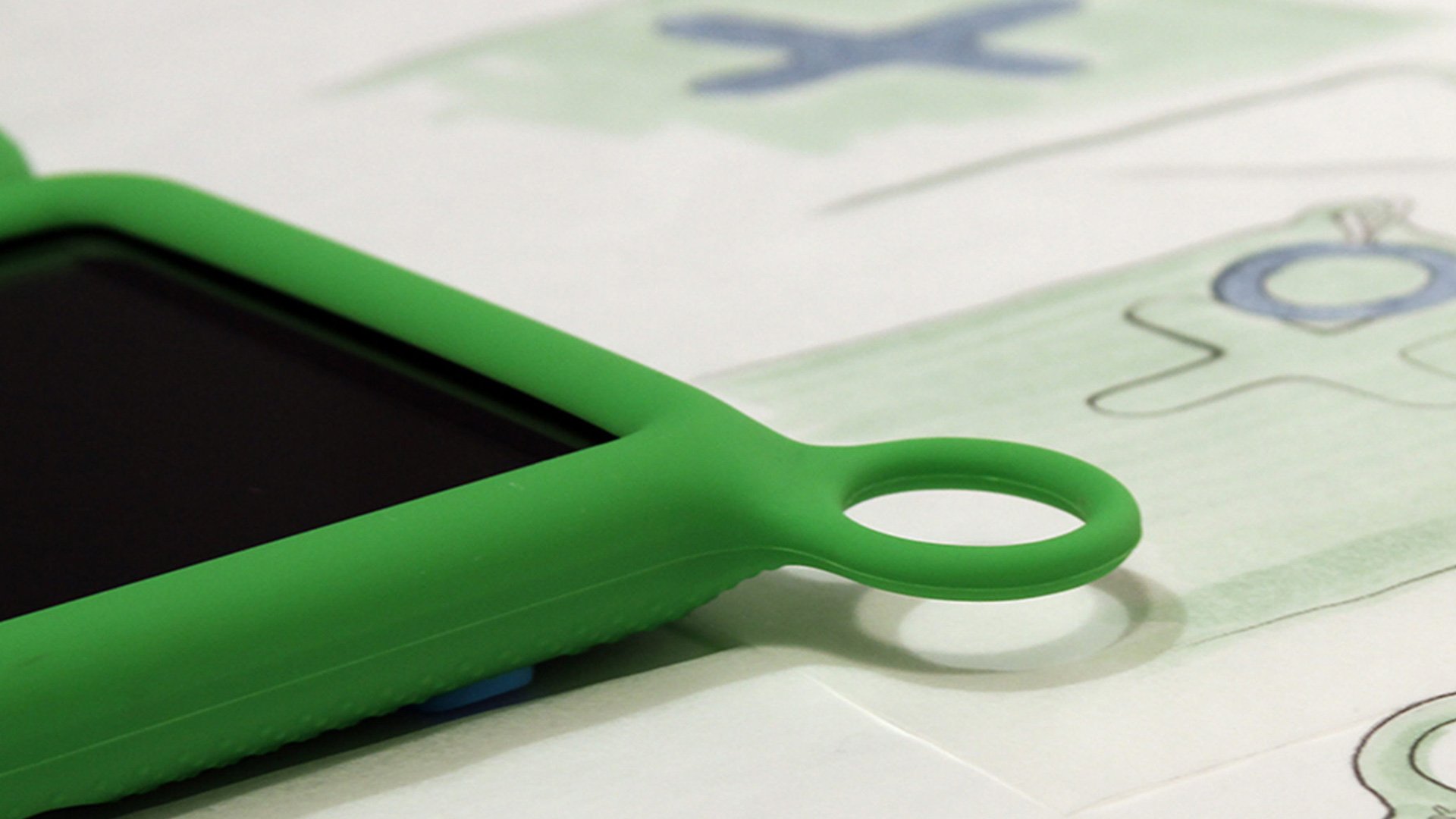 OLPC XO Tablet design tool: pair of green-handled scissors with silver ring resting on cardstock