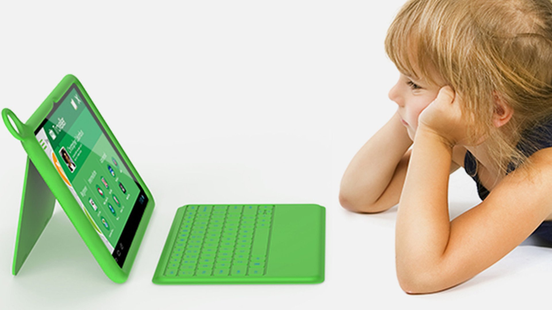 OLPC XO Laptop: young child seated at a table engaging with the green XO laptop in an educational setting