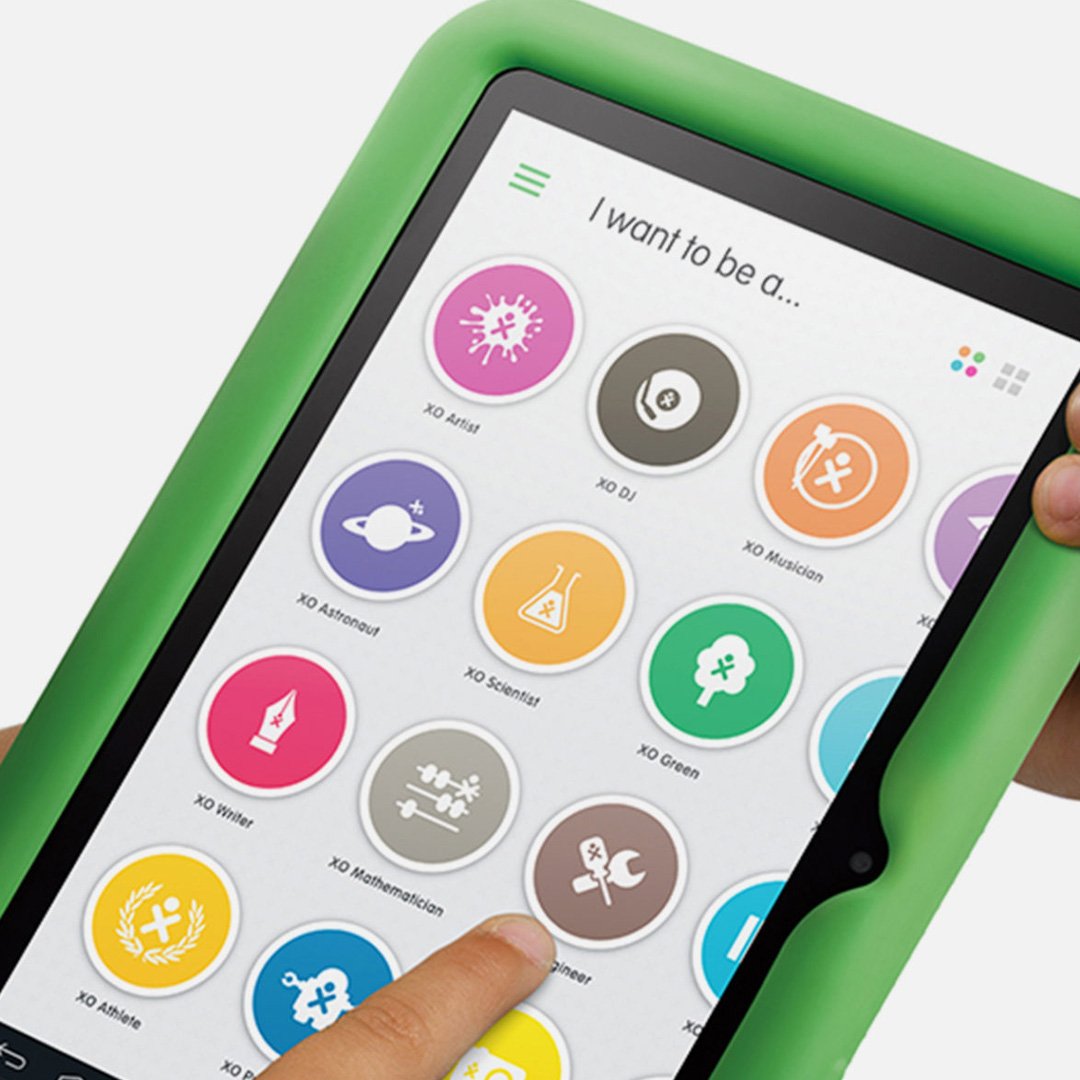 OLPC XO Tablet held in hand displaying I want to be career options including scientist, healthy and brave