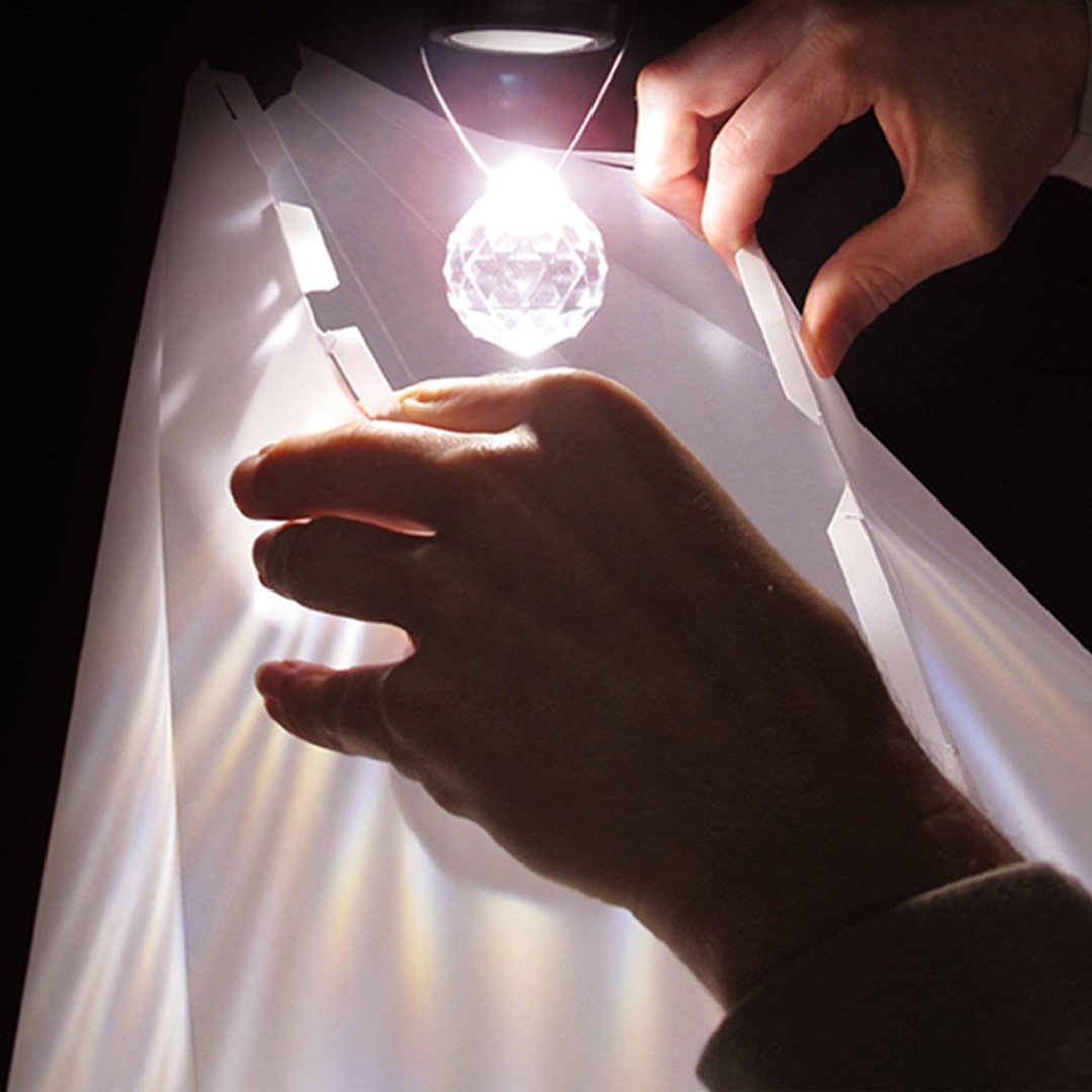 Person places crystal ball on a white surface
