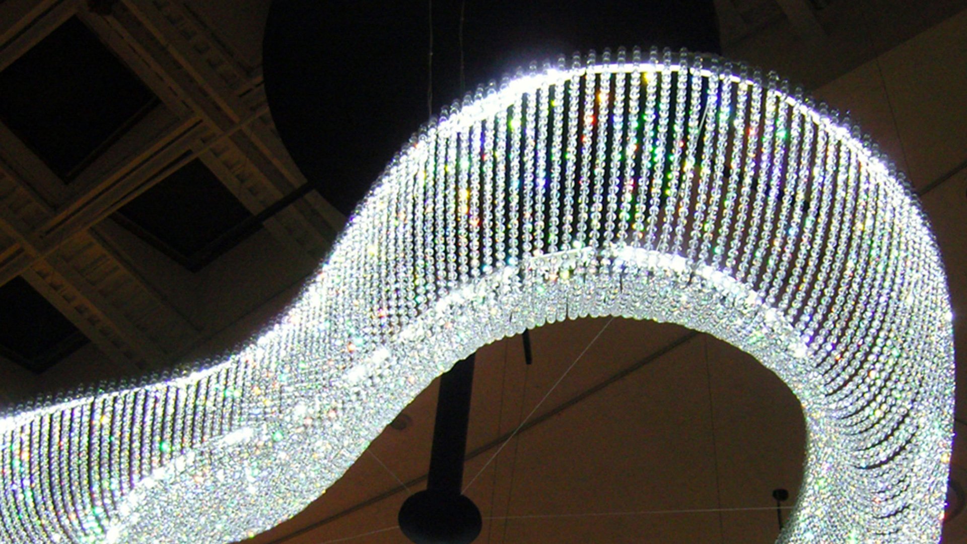 Illuminated crystal chandelier with wavy design and glass elements