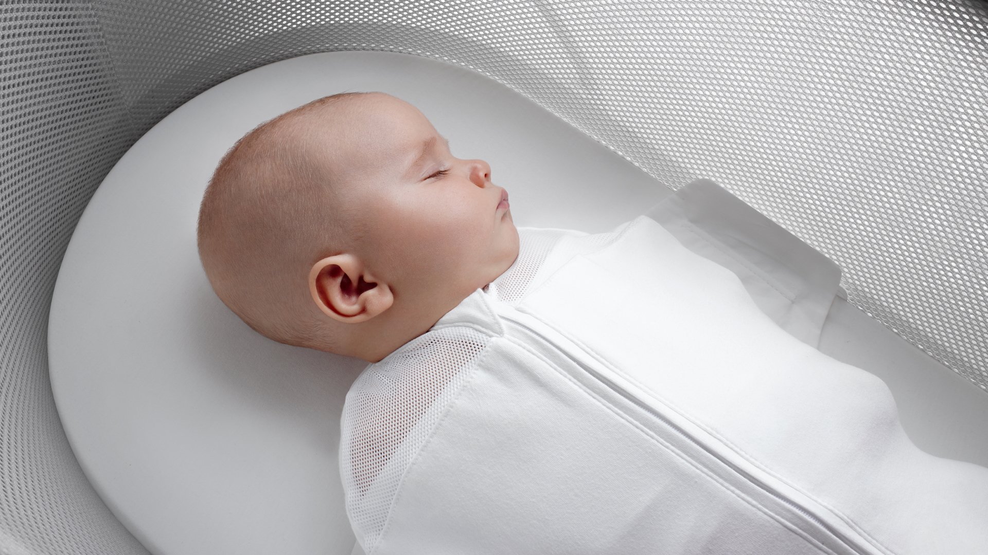 Swaddled baby sleeping in Snoo bassinet