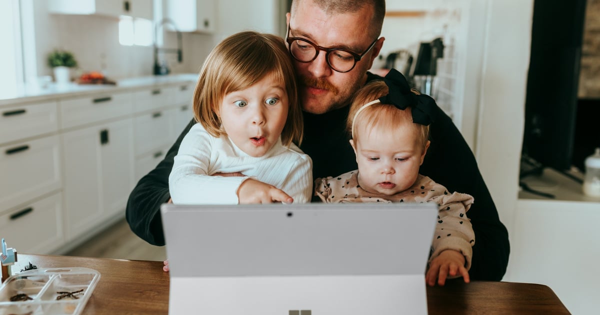a man and two children looking at a laptop