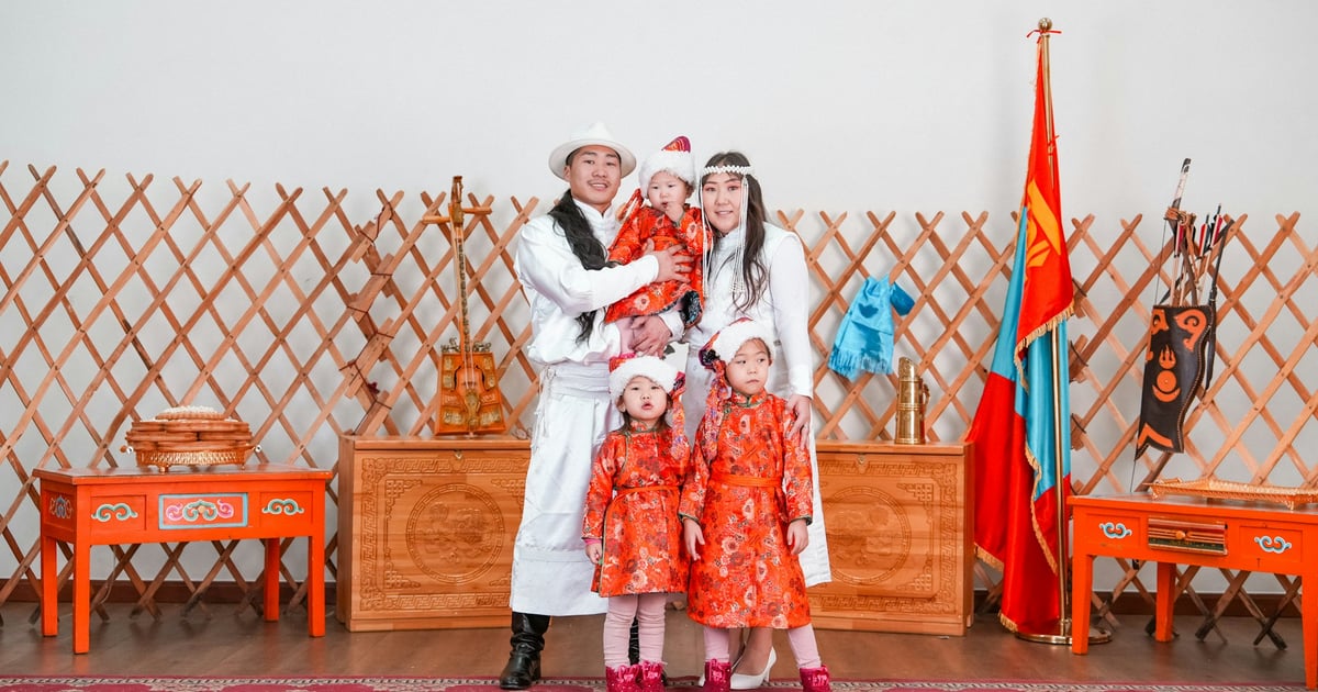 Family in traditional mongolian clothing posing for a photo