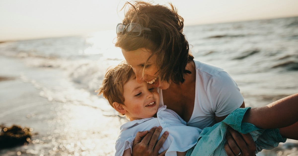 photo of mother and child beside body of water