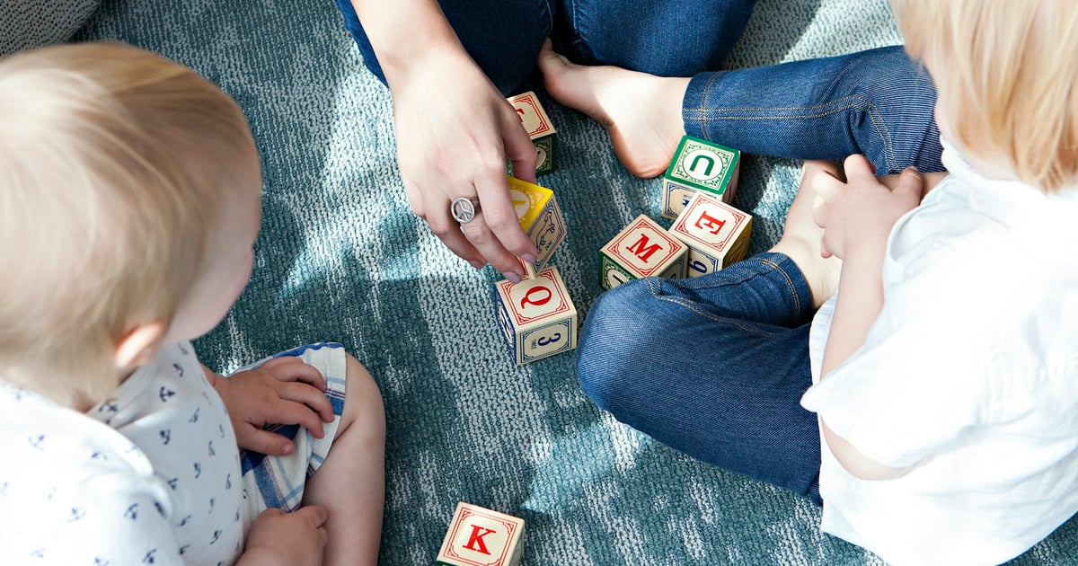 two toddler playing letter cubes