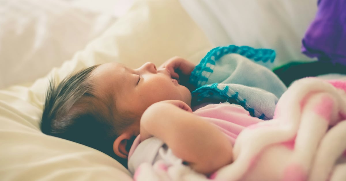 baby sleeping on bed
