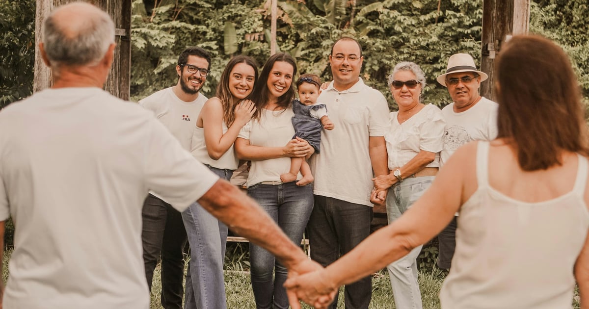 a group of people holding hands in front of trees