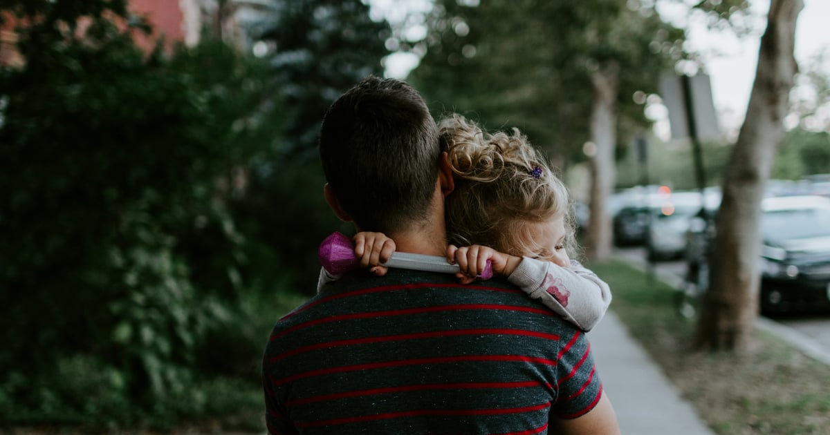 man wearing gray and purple striped crew-neck shirt carrying toddlers