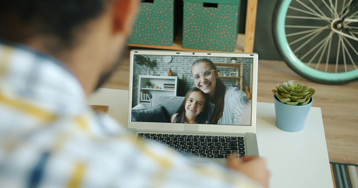 Man video calls with a woman and child.