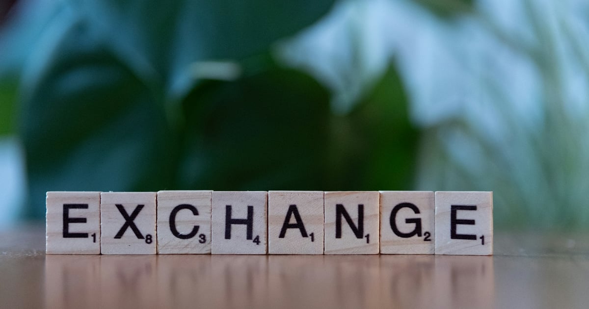 A scrabble block spelling the word exchange on a table