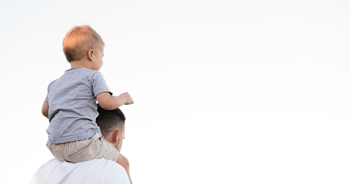 man in white shirt carrying boy