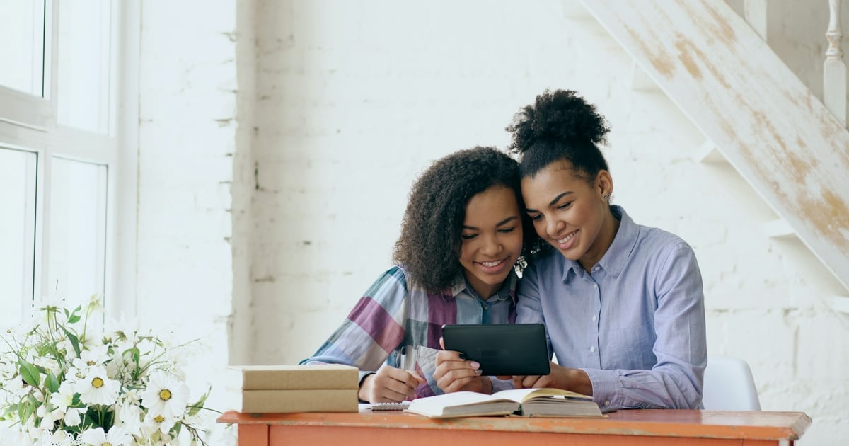Two women reading a book together
