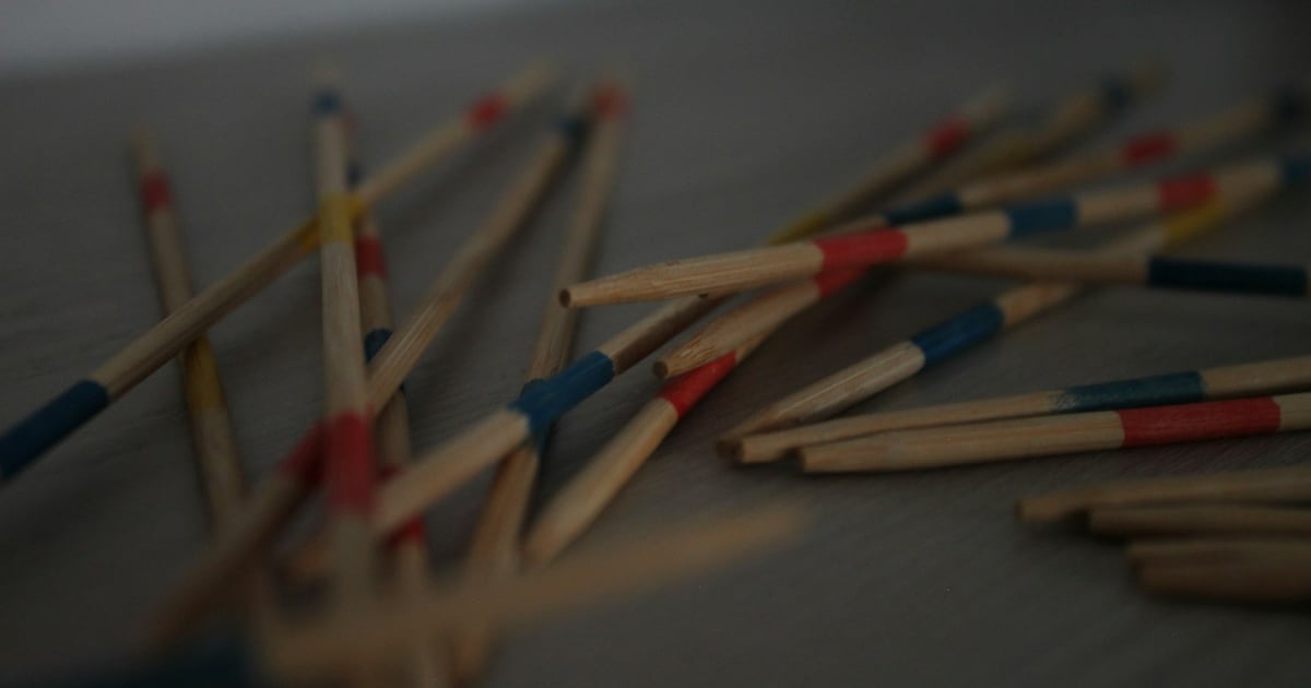 Pile of colorful pick-up sticks scattered on a surface.