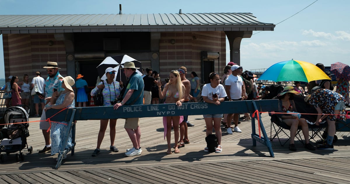 People gathered on a boardwalk near a building.