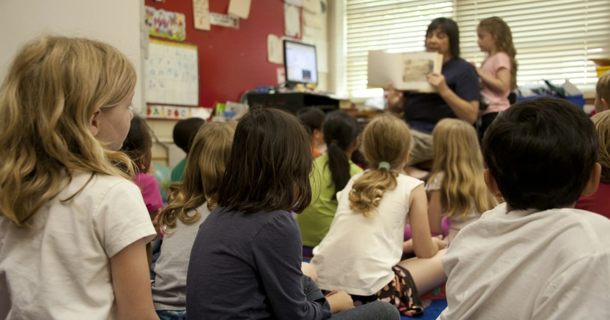 A group of children sitting on a classroom floor listening to a story