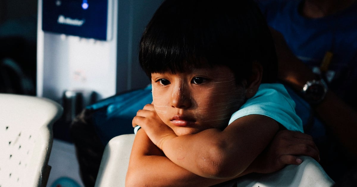 boy leaning on white chair