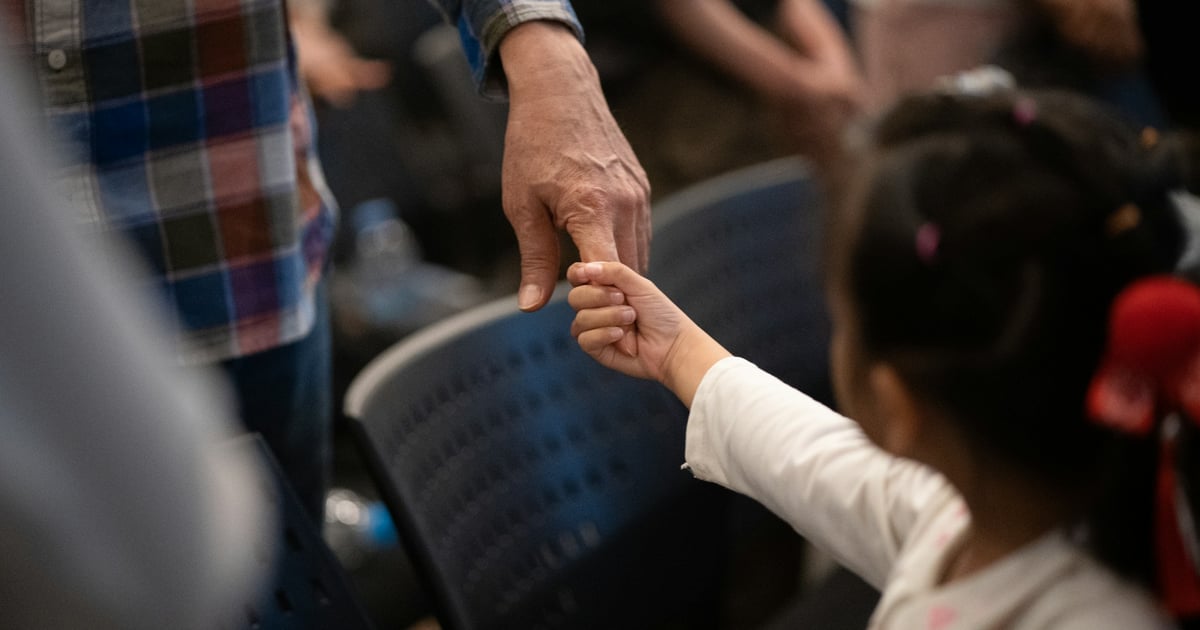 Adult hand holding a child's hand