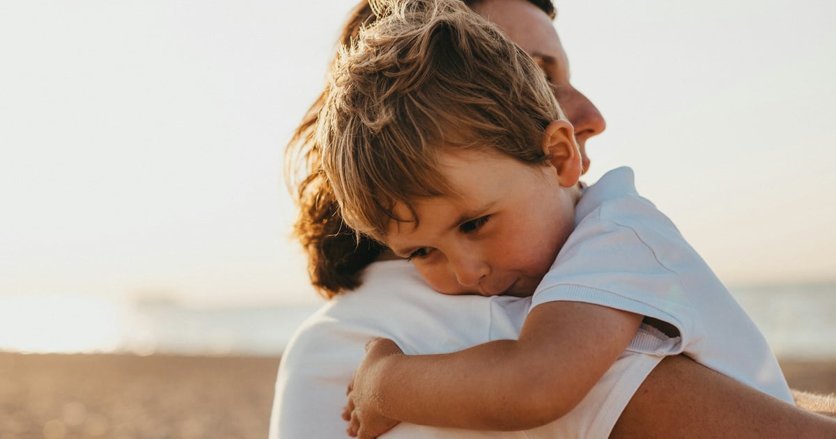 boy hugging woman during daytime