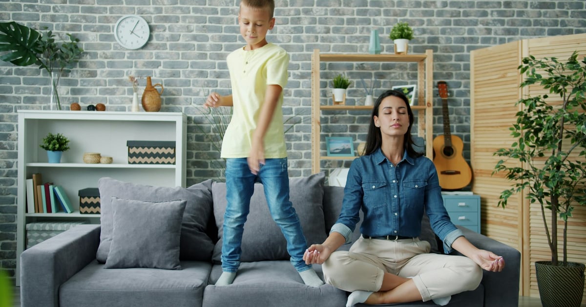 Mother meditates while son dances on couch