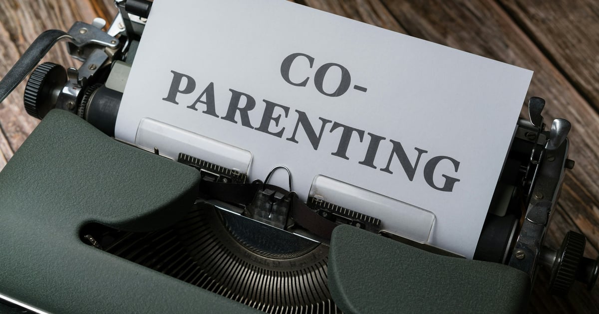 a close up of a typewriter with a paper that says co - parenting