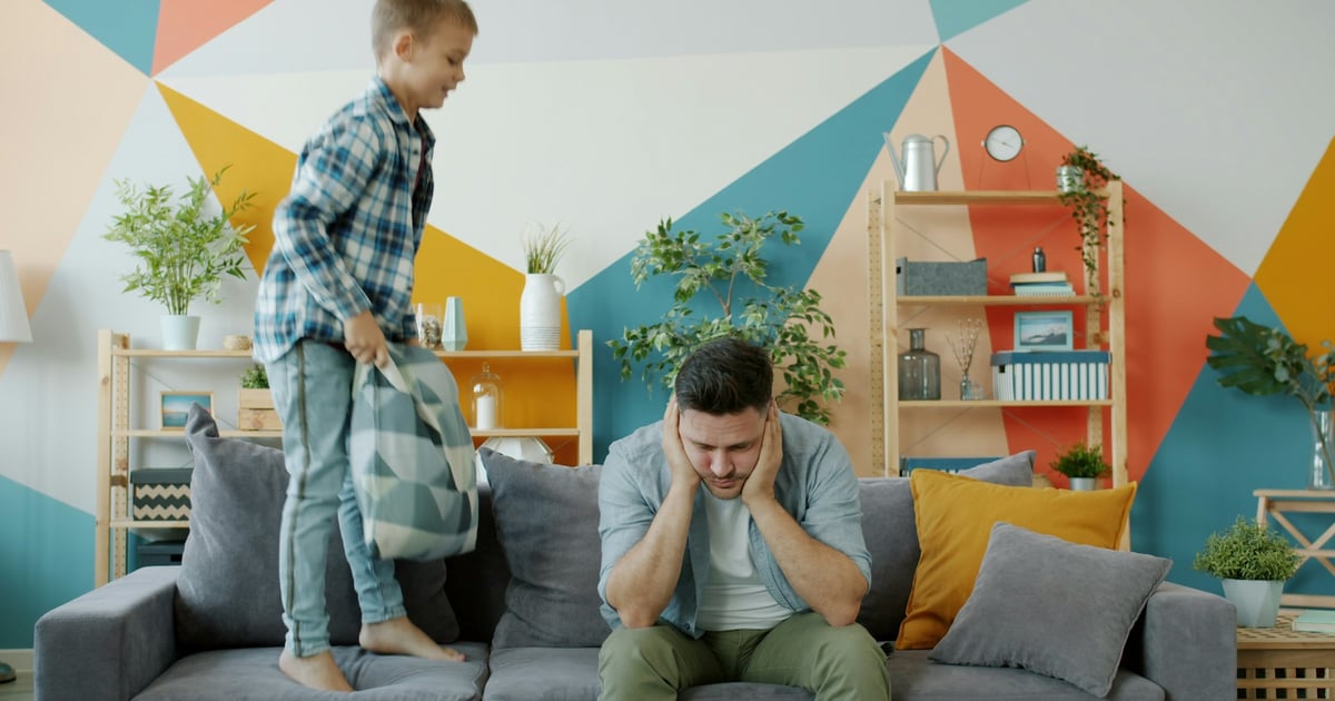 Father stressed as son jumps on couch