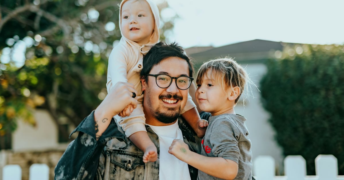 man in white shirt carrying girl in gray shirt