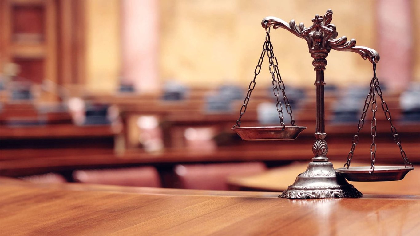Brass scales of justice on a courtroom table