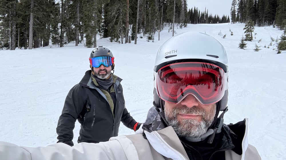 A selfie of Josh and me, Josh on the left in a black jacket and black helmet and me on the right in a cream jacket and white helmet.