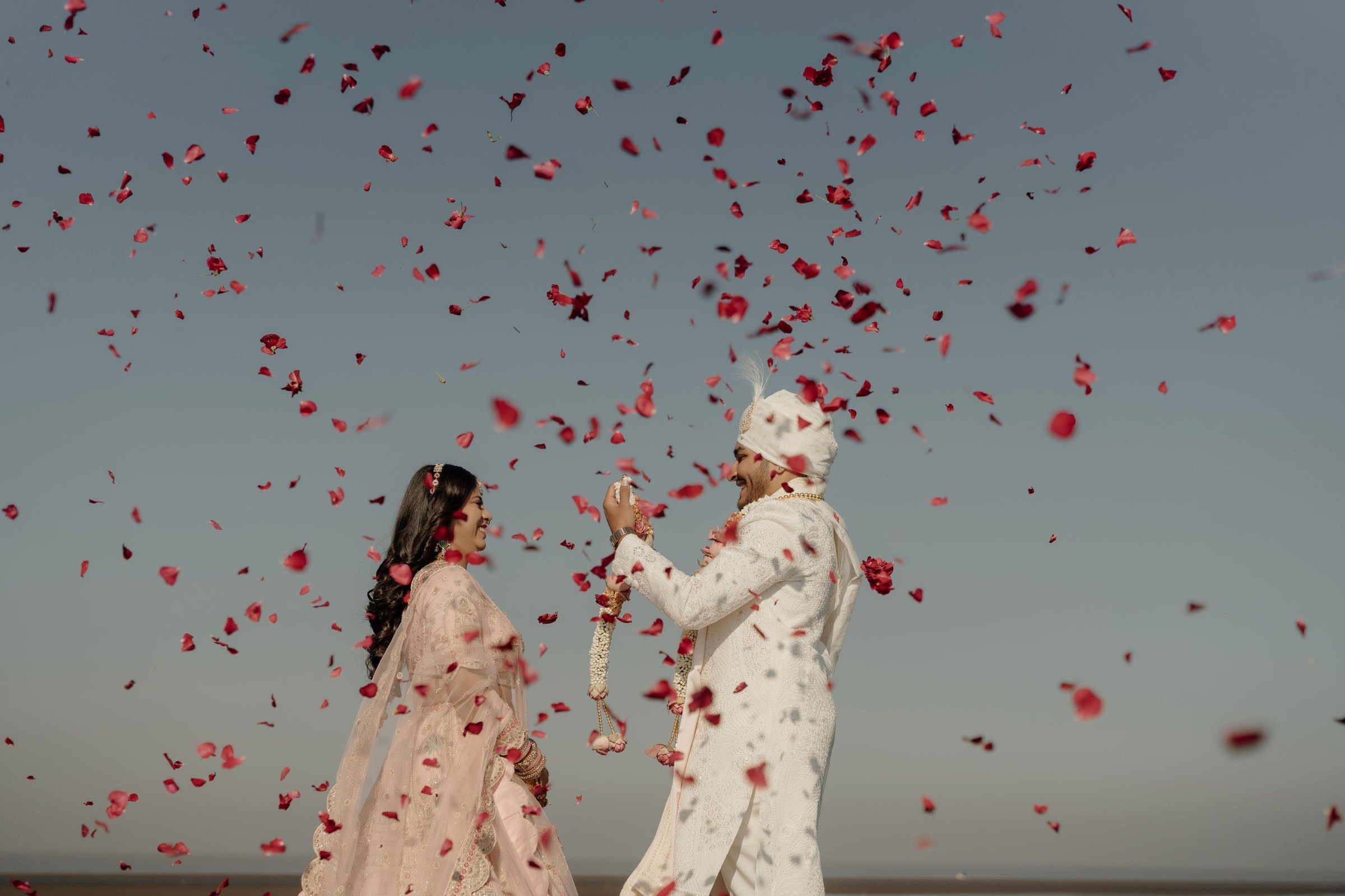 Cousins let the petals fly as the couple step out