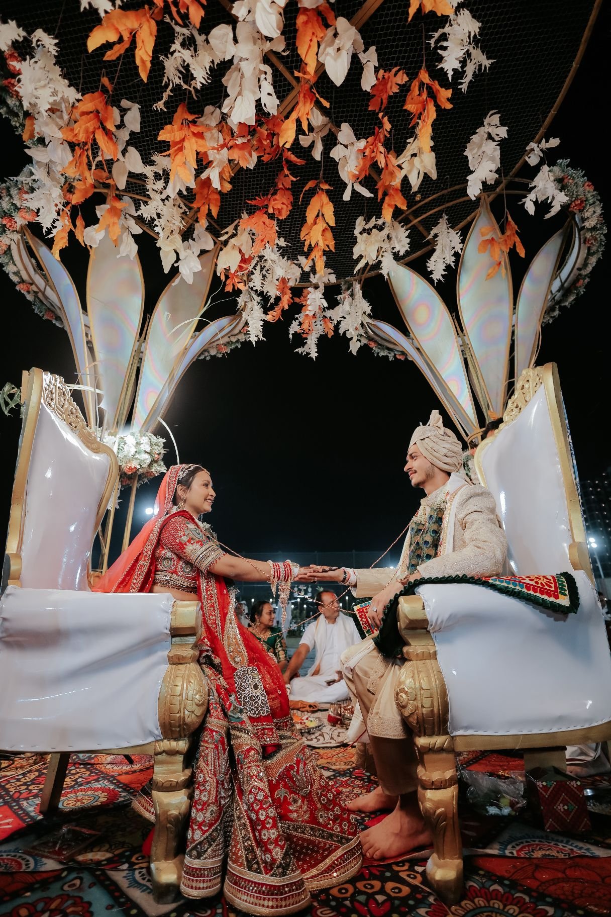 Pheras under the floral mandap, lit for the night