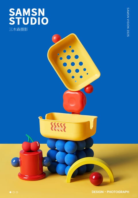 This image exemplifies a bold, pop-art-inspired 3D product photography style with a strong graphic design sensibility. The visual aesthetic is characterized by clean, photorealistic rendering of geometric objects, presented with a flat, almost illustrative quality due to the stark color blocking and minimal depth of field. The color language is dominated by a high-saturation, primary color palette of vibrant cobalt blue, lemon yellow, and cherry red, creating a high-contrast, energetic composition with a cool overall color temperature from the dominant blue background. Lighting is directional and hard, casting crisp, defined shadows that emphasize the three-dimensionality of the objects while maintaining a bright, commercial feel. The texture and material feel are smooth and glossy, with a plastic-like sheen on the colored objects, contrasted by the matte, porous texture of the blue spherical cluster. Compositionally, the image uses a centered, vertical stack of objects against a flat, two-tone background (blue wall, yellow floor), creating a playful, precarious balance with a shallow depth of field. The shape language is a mix of strict geometric forms (spheres, cubes, arches) and playful, rounded organic elements (the cherry-like forms), with clean, sharp edges. The overall mood is energetic, playful, and meticulously styled, conveying a sense of modern, graphic design-focused product art.