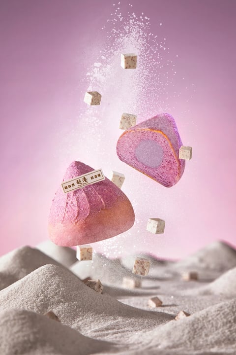 This image is a high-end, photorealistic 3D render with a commercial product photography aesthetic, designed as a dynamic style reference. The color language is dominated by a soft, gradient pink-to-lavender background, creating a warm, pastel, and feminine palette. The primary subject is a purple and pink triangular pastry, with its vibrant magenta and violet hues providing a saturated focal point against the softer backdrop. The lighting approach is soft and diffused, emanating from the upper left, casting gentle, soft-edged shadows that enhance the three-dimensional form of the floating pastry and ingredients without creating harsh contrast. The texture and material feel are meticulously rendered: the pastry has a fine, powdery, slightly porous surface, while the scattered white cubes (likely cheese or taro) have a smooth, matte finish with subtle internal speckles. A fine, sparkling powder is frozen in mid-air, adding a granular, ethereal texture. Compositionally, the image uses a dynamic, floating arrangement with a shallow depth of field, placing the main pastry and ingredients in sharp focus against a blurred, undulating landscape of powder below. The shape language combines the organic, soft triangular form of the pastry with the precise geometric cubes, all treated with soft, rounded edges. The overall mood is dreamy, airy, and whimsical, conveying a sense of lightness and magical suspension.