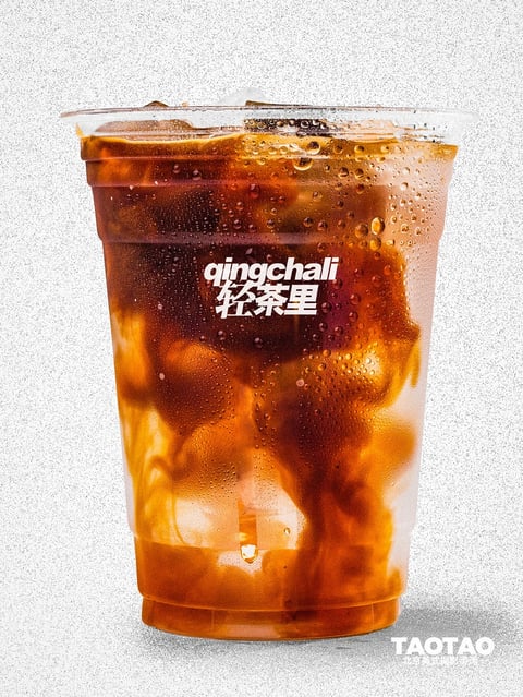 This image presents a photorealistic, high-detail product shot of a clear plastic cup filled with an iced amber-colored beverage, likely tea or coffee, against a textured, light gray speckled background. The visual aesthetic is clean and commercial, with a hyper-realistic rendering technique that emphasizes clarity and detail. The color language is dominated by a warm palette of deep amber, burnt orange, and golden yellow hues within the liquid, contrasted against the cool, neutral gray of the background and the crisp white of the logo text. Saturation is high within the drink itself, showcasing rich, translucent tones, while the overall image maintains a balanced contrast that highlights the liquid's depth and the cup's form. Lighting is directional and bright, appearing to come from the upper left, creating soft highlights on the cup's rim and the condensation droplets, and casting subtle shadows that enhance the three-dimensionality of the ice cubes and liquid swirls. The texture and material feel are highly tactile: the cup's surface is rendered with realistic condensation droplets of varying sizes, giving a wet, chilled impression, while the liquid inside shows a viscous, swirled texture with suspended ice cubes that appear solid and cold. The composition is centered and straightforward, with the cup occupying the majority of the frame in a vertical orientation, creating a strong focal point with minimal depth of field that keeps the entire subject in sharp focus. Shape language combines the geometric, tapered cylinder of the cup with the organic, irregular forms of the ice cubes and the fluid, swirling patterns of the liquid inside. The mood and atmosphere are refreshing, crisp, and appetizing, conveying a sense of coolness and indulgence through the detailed rendering of the chilled beverage.