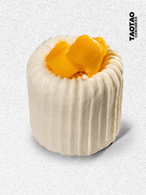 This image presents a photorealistic, studio-style photograph of a single, cylindrical pastry or dessert, centered against a subtly textured, light gray, speckled background. The aesthetic is clean and minimalist, emphasizing the subject with high clarity and a tactile, almost 3D-rendered quality. The color palette is dominated by a soft, creamy off-white of the pastry's fluted exterior, contrasted sharply by the vibrant, glossy, golden-orange chunks of fruit (likely mango or peach) nestled in its center. The lighting is soft and directional, coming from the upper left, casting gentle shadows that define the pastry's vertical ridges and create a subtle, diffused shadow to its right, enhancing its three-dimensional form without harshness. The texture is highly detailed, showcasing the smooth, matte, slightly porous surface of the pastry against the wet, glistening, and translucent appearance of the fruit. The composition is tightly framed, focusing entirely on the object with ample negative space around it, creating a balanced and elegant presentation. The shape language combines the geometric regularity of the cylindrical, fluted form with the organic, irregular shapes of the fruit pieces. The overall mood is serene, appetizing, and refined, conveying a sense of premium quality and delicate craftsmanship.