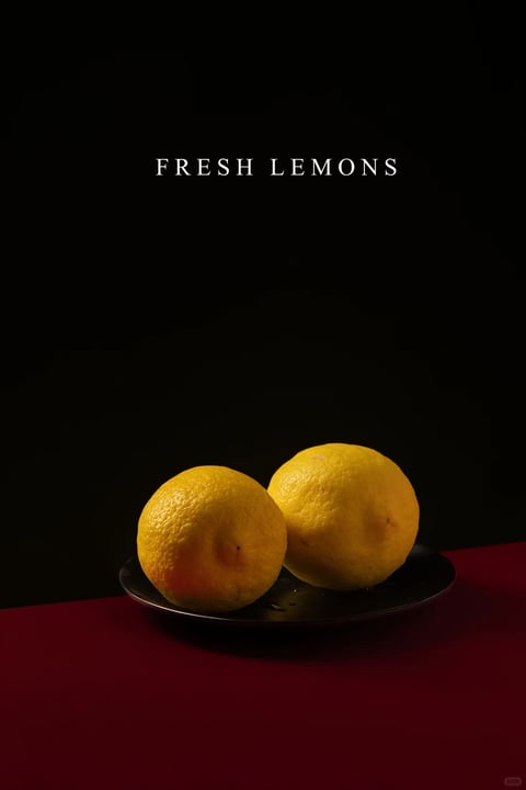 This image presents a photorealistic still life with a minimalist, high-contrast aesthetic. The color language is dominated by a stark black background, a deep crimson red surface, and the vibrant, saturated yellow of the two lemons, creating a bold and dramatic palette. The lighting is directional and soft, likely from the upper left, casting gentle highlights on the textured, pitted skin of the lemons and creating soft, defined shadows on the dark plate and red surface, evoking a moody, focused atmosphere. The texture and material feel are highly tactile, emphasizing the organic, bumpy rind of the fruit against the smooth, matte finish of the plate and the flat, non-reflective red plane. Compositionally, the image uses a centered, symmetrical arrangement with significant negative space above, framing the lemons on the plate as the sole focal point within a shallow depth of field. The shape language is primarily organic, defined by the round, irregular forms of the lemons, with clean, sharp edges where the red surface meets the black void. The overall mood is serene, sophisticated, and slightly dramatic, with a quiet visual weight centered on the simple, fresh subject matter.