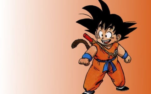 The image features a classic anime illustration of a young boy character, rendered in a flat, cel-shaded style with bold, clean black outlines defining all forms. The color language is vibrant and saturated, dominated by a warm palette: the character's gi is a bright, energetic orange, contrasted with deep blue wristbands, sash, and boots, and set against a smooth, gradient background that transitions from pale peach on the left to a richer, warm orange on the right. The lighting is simple and directional, appearing to come from the upper left, casting soft, defined shadows that give the character a subtle sense of volume without complex rendering. Textures are minimal and implied through flat color blocks and line work, emphasizing a graphic, illustrative feel rather than tactile realism. The composition centers the character in a dynamic, forward-facing stance, occupying the right two-thirds of the frame with negative space on the left, creating a sense of readiness and potential movement. The shape language is a mix of organic, rounded forms for the character's body and face, and sharp, angular spikes for the hair, with consistent, medium-weight linework. The overall mood is cheerful, energetic, and nostalgic, evoking a classic Saturday morning cartoon atmosphere with high visual energy and a lighthearted tone.