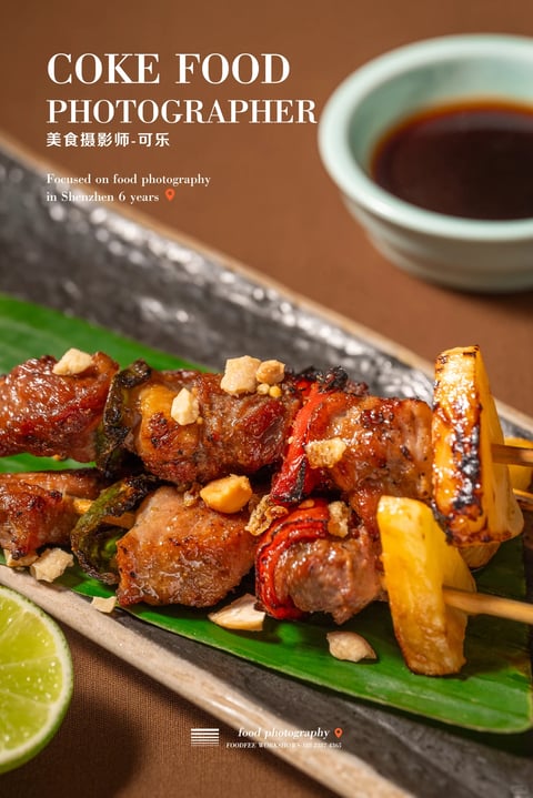 This is a photorealistic food photography image with a warm, inviting aesthetic. The dominant color palette features rich, warm tones: deep amber and mahogany glazes on the meat, vibrant golden-yellow pineapple chunks, and bright red pepper accents, all set against a muted, earthy brown background. The lighting is soft yet directional, likely from the upper left, creating gentle highlights on the glossy sauce and subtle shadows that enhance the three-dimensional form of the skewers. The image exhibits high contrast, with the dark, textured plate and deep sauce in the background contrasting against the brightly lit food. Textures are rendered with tactile detail: the sticky, caramelized surface of the meat, the slightly charred edges of the pineapple and peppers, and the rough, uneven surface of the crushed nuts sprinkled on top. The composition is a close-up, slightly angled shot that fills the frame with the food, using a shallow depth of field to keep the foreground skewers sharp while softly blurring the background elements like the sauce bowl. The shapes are predominantly organic, with the irregular forms of the meat and vegetables, though the plate and bowl introduce softer geometric curves. The overall mood is appetizing and sophisticated, conveying a sense of careful preparation and indulgent flavor.