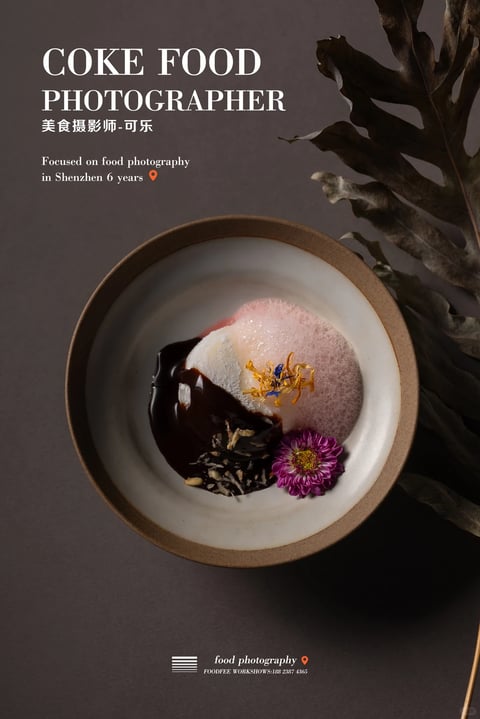 This image is a photorealistic food photography shot with a sophisticated, moody aesthetic. The color language is dominated by a muted, desaturated palette of deep charcoal grays, warm taupe, and earthy browns, punctuated by the rich, glossy dark chocolate sauce, the soft pink foam, and the vibrant purple and yellow floral garnishes. The lighting is directional and soft, appearing to come from the upper left, creating gentle highlights on the glossy sauce and the foam's texture while casting deep, soft shadows that enhance the dish's three-dimensionality and create a dramatic, intimate mood. The texture and material feel are highly detailed, showcasing the smooth, reflective surface of the chocolate, the airy, porous quality of the foam, the delicate, fibrous petals of the flowers, and the rough, matte, speckled ceramic of the bowl's rim. The composition is a centered, overhead flat lay, with the circular bowl as the focal point, framed by a large, dark, dried leaf on the right that adds organic asymmetry and depth. Shape language contrasts the perfect, hard-edged geometric circle of the bowl with the soft, organic, flowing forms of the food components and the jagged, natural lines of the leaf. The overall mood is elegant, serene, and contemplative, with a low-energy, visually heavy atmosphere that emphasizes culinary artistry and quiet sophistication.