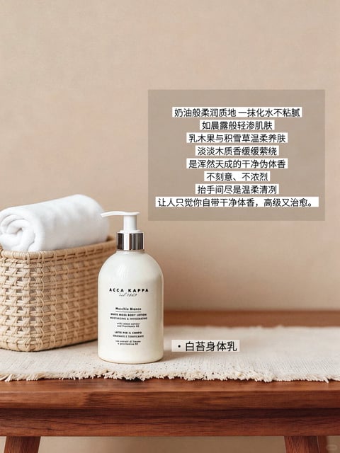 The image presents a warm, serene still-life composition centered on a white pump bottle of Acca Kappa 'Muschio Bianco' white moss body lotion, placed on a textured off-white woven mat atop a rich wooden surface. To the left, a woven wicker basket holds a neatly rolled white towel, adding a natural, tactile element. The background is a smooth, solid beige wall, creating a minimalist and calming backdrop. Visually, the style is photorealistic with a soft, high-end commercial aesthetic, characterized by a warm, neutral color palette dominated by creamy whites, soft beiges, and the warm brown of the wood. The lighting is soft and diffused, appearing to come from the upper left, casting gentle shadows that enhance the three-dimensional form of the objects without harsh contrast, evoking a gentle, soothing mood. The textures are rendered with tactile clarity: the smooth, matte ceramic-like finish of the bottle, the woven intricacy of the basket, the soft pile of the towel, and the nubby weave of the mat. The composition is balanced and slightly asymmetrical, with the bottle as the focal point, framed by the basket and mat. The text elements are integral to the image's function as a product moodboard. A semi-transparent beige rectangle in the upper right contains multiple lines of descriptive Chinese text in a clean, black sans-serif font, outlining the product's qualities like its 'butter-like soft texture,' 'woody scent,' and 'clean, advanced, and healing' sensory experience. Below the bottle, a smaller white label with black text identifies the product in Chinese as '白苔身体乳' (White Moss Body Lotion). The visible product label on the bottle itself features black serif and sans-serif typography in both English and Italian, detailing the brand 'ACCA KAPPA', product name, and key ingredients like lemon extract and pro-vitamin B5. The overall mood is one of understated luxury, cleanliness, and gentle self-care.