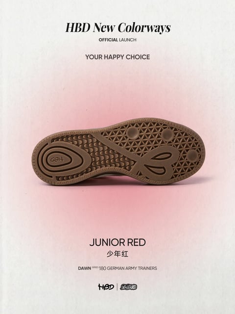 The image presents a minimalist product advertisement centered on the sole of a sneaker, captured in a close-up, horizontal composition against a softly textured, pale pink background that fades to off-white at the edges. The primary subject is the brown rubber outsole of a shoe, featuring an intricate pattern of geometric treads: a central section with a dense triangular grid, flanked by concentric oval ridges at the heel and forefoot, and a stylized 'B' logo near the toe. The sole is rendered with a photorealistic finish, emphasizing its matte, slightly grainy rubber texture and the depth of its molded grooves. Visible text is integrated into the composition: at the top, 'HBD New Colorways' appears in a bold, black serif font, followed by 'OFFICIAL LAUNCH' in a smaller sans-serif font below it, and the tagline 'YOUR HAPPY CHOICE' in a clean sans-serif font centered above the sole. At the bottom, 'JUNIOR RED' is displayed in large, black sans-serif letters, with the Chinese characters '少年红' directly beneath, and smaller text reading 'DAWN SERIES 180 GERMAN ARMY TRAINERS' above two brand logos ('HBD' and 'Dawn 180') at the very bottom. The lighting is soft and diffused, casting gentle, subtle shadows beneath the sole to create a slight sense of depth without harsh contrasts, contributing to a calm, elegant, and modern mood. The color palette is muted and cohesive, dominated by warm taupe-brown for the sole and a soft, desaturated pink for the background, with high contrast between the dark text and light surfaces, and a warm overall color temperature.