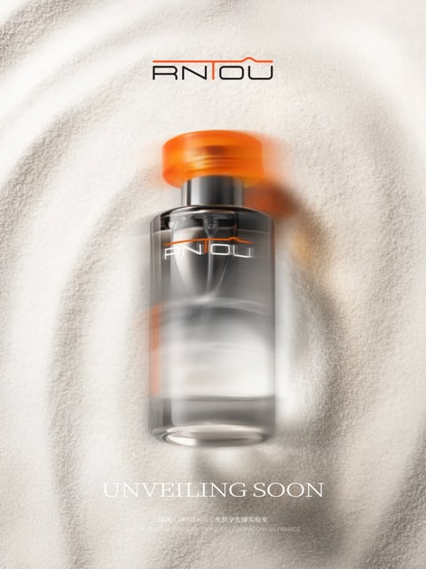 This image presents a high-end product advertisement for a skincare serum, centered on a clear glass bottle with a vibrant orange cap and metallic silver neck, positioned vertically against a soft, swirling, sand-like background. The composition is tightly framed, with the bottle as the sole focal point, creating a minimalist and luxurious aesthetic. The visual style is photorealistic with a slight motion blur effect applied to the bottle, suggesting dynamism or a 'coming soon' reveal. The color palette is dominated by neutral, cool-toned whites and silvers of the background, sharply contrasted by the warm, saturated orange of the cap and the brand logo, creating a striking visual anchor. Lighting is soft and diffused from above, casting gentle, blended shadows that emphasize the bottle's rounded form and the granular texture of the background material, which resembles fine, flowing powder or sand. The texture of the glass is rendered as smooth and reflective, while the cap appears matte, and the background has a delicate, tactile granularity. Visible text includes the brand logo 'RNTOU' in a sleek, modern sans-serif font with an orange line accent, appearing both at the top of the image and on the bottle itself. At the bottom, the phrase 'UNVEILING SOON' is written in a clean, white serif font, with smaller Chinese characters and English text below stating '法国 LBTISKIN 皮肤学先锋实验室' and 'LBTISKIN DERMATOLOGY PIONEER LABORATORY IN FRANCE,' indicating the product's origin and scientific branding. The overall mood is sophisticated, anticipatory, and clean, with a focus on the product's imminent launch.