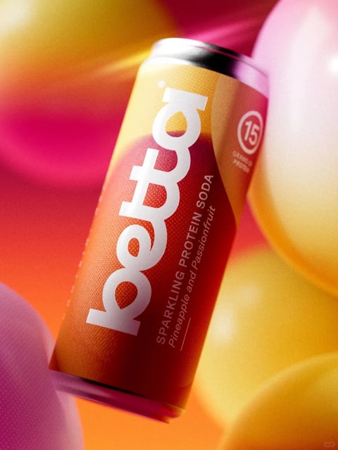 The image presents a vibrant, photorealistic 3D rendering of a sleek, cylindrical beverage can angled dynamically against a soft, abstract background of blurred, balloon-like forms. The can, the primary subject, features a warm, gradient color scheme transitioning from a sunny yellow-orange at the top to a deep, rich crimson-red at the bottom, with a fine, granular texture that suggests a matte, slightly tactile finish. Dominating the can's surface is the brand name 'lofty' rendered in large, bold, white sans-serif letters that run vertically, their clean lines contrasting sharply with the warm background. Below this, smaller white text reads 'SPARKLING PROTEIN SODA' and 'Pineapple and Passionfruit,' indicating the product type and flavor. A circular emblem near the top right contains the number '15' with 'GRAMS PROTEIN' below it, highlighting a key nutritional feature. The lighting is soft and diffuse, casting gentle highlights on the metallic rim and the curved surface of the can, enhancing its three-dimensional form without harsh shadows. The background consists of out-of-focus, smooth, rounded shapes in complementary shades of magenta, pink, and yellow, creating a dreamy, energetic atmosphere with a shallow depth of field that keeps the can sharply in focus. The overall composition is tight and product-centric, with the diagonal orientation of the can adding a sense of movement and modernity, evoking a mood of vibrant, health-conscious indulgence.