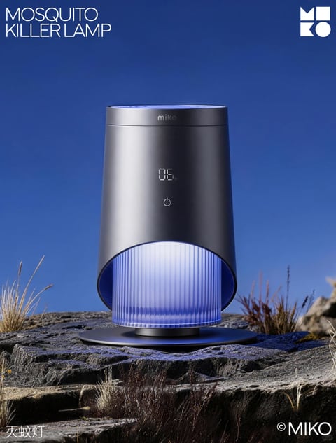 The image presents a sleek, modern Mosquito Killer Lamp as the central subject, positioned on a rugged, gray rock surface against a clear, deep blue sky, creating a striking contrast between high-tech design and natural textures. The composition uses a low-angle shot, placing the device prominently in the center foreground to emphasize its form and presence, with sparse, dry grasses flanking it to add environmental context without distraction. The visual aesthetic is photorealistic and polished, featuring clean 3D rendering with precise details and smooth gradients. The color language is dominated by a cool palette: the lamp's matte black metallic body contrasts with the vibrant blue LED light emitting from its lower translucent chamber, while the sky provides a saturated, uniform backdrop. Lighting is directional and soft, likely mimicking natural daylight, casting gentle highlights on the lamp's curved surfaces and creating subtle shadows that enhance its three-dimensional form. Texture and material feel are clearly defined: the lamp exhibits a brushed metal texture with a smooth, matte finish, while the base shows a reflective, glossy quality; the rock surface has a rough, weathered appearance with visible cracks and grain. The shape language combines geometric precision—cylindrical and rounded forms with clean edges—with organic elements from the natural rock and grass. Mood and atmosphere convey a sense of advanced technology integrated with outdoor resilience, feeling both sophisticated and functional. Visible text includes 'MOSQUITO KILLER LAMP' in bold, white sans-serif font at the top left, the brand name 'miko' in lowercase on the lamp's upper body, a digital display showing '06 h' and a power icon on the lamp's front, the brand logo 'MIKO' with a geometric symbol at the top right, the Chinese characters '灭蚊灯' (meaning mosquito killer lamp) at the bottom left, and the copyright '© MIKO' at the bottom right, all serving branding and informational roles.