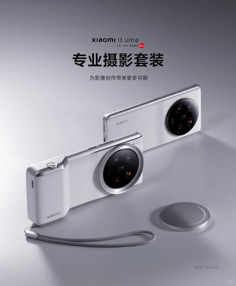 The image showcases a sleek, modern photographic accessory kit for the Xiaomi 13 Ultra smartphone, presented in a clean, minimalist studio setting. The composition features a silver-toned smartphone with a large circular Leica camera module as the central subject, positioned at a slight angle. Attached to its side is a matching silver and white photographic grip, complete with a physical shutter button and a branded strap, transforming the phone into a camera-like device. A separate, circular silver lens cap lies on the surface nearby. The overall visual aesthetic is photorealistic 3D rendering with a high-end, product-focused style. The color language is restrained and sophisticated, dominated by a monochromatic palette of cool silver, white, and matte grey, with the deep black of the camera lens providing strong contrast and subtle gold accents within the lens optics adding a touch of warmth. The lighting is soft and directional, coming from the upper left, creating gentle gradients and soft shadows that define the forms and materials without harshness, conveying a mood of precision and quality. Texture and material rendering emphasize smooth, anodized aluminum, matte polycarbonate, and glass, with a tactile contrast between the cool metal and the fabric strap. The composition uses a diagonal arrangement and overlapping elements to create depth, with the foreground grip and background phone creating a clear visual hierarchy. Shape language is predominantly geometric, with clean lines, sharp edges on the phone and grip, contrasted by the perfect circle of the camera module and lens cap. The mood is professional, aspirational, and technologically refined. Visible text includes "Xiaomi 13 Ultra" and the Leica logo in small print at the top center, followed by the large, bold Chinese characters "专业摄影套装" (Professional Photography Kit) and the smaller subheading "为影像创作带来更多可能" (Bring more possibilities to image creation). A disclaimer in small text at the bottom right reads "*套装不包含手机" (*Kit does not include the phone).