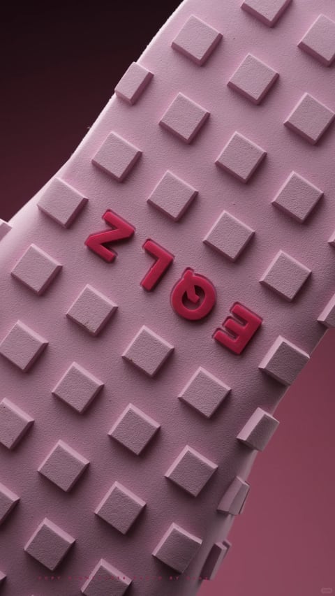 The image is a photorealistic 3D close-up render of a textured, geometric surface, presented in a diagonal, dynamic composition. The main subject is a light mauve or lavender-pink surface covered in a repeating grid of slightly raised, square protrusions, each with a matte, subtly grainy finish. Centered on this grid is the stylized text 'N763', rendered in a bold, rounded, three-dimensional sans-serif font. The characters are a glossy, deep crimson red, creating a strong focal point and a slight visual pop against the muted background. The lighting is soft and directional, appearing to come from the upper left, casting gentle, soft-edged shadows to the lower right of each square protrusion and the letters, which enhances the sense of depth and tactile quality. The overall color palette is monochromatic and low-saturation, dominated by cool lavender-pinks, with the high-contrast red text as the sole accent. The mood is minimalist, modern, and slightly abstract, with a clean, architectural feel derived from its repetitive geometric shapes and controlled rendering.