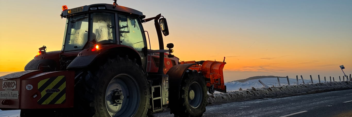 Tractor with snow plow at Cat and Fiddle in snowy sunset