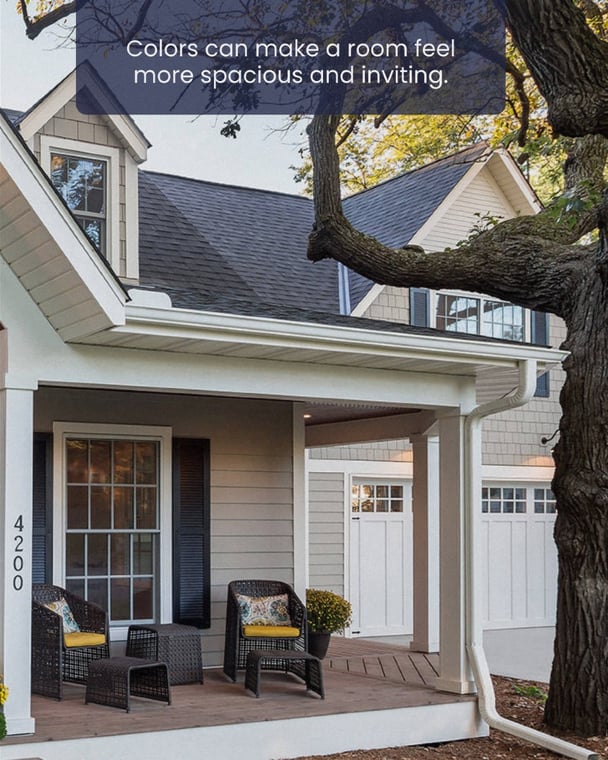 This is an image from Suetam Painting & Finishes. It shows the exterior of a house with a front porch featuring wicker chairs, yellow cushions, and decorative pillows, alongside freshly painted siding in neutral tones that enhance curb appeal.
